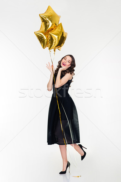 Charming smiling young curly female holding balloons Stock photo © deandrobot