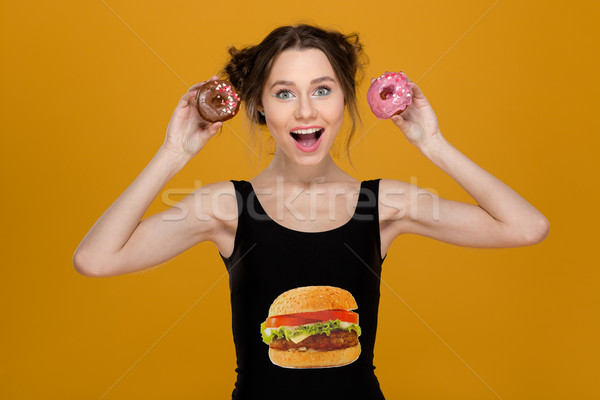 Lovely woman in black top with hamburger print holding donuts  Stock photo © deandrobot
