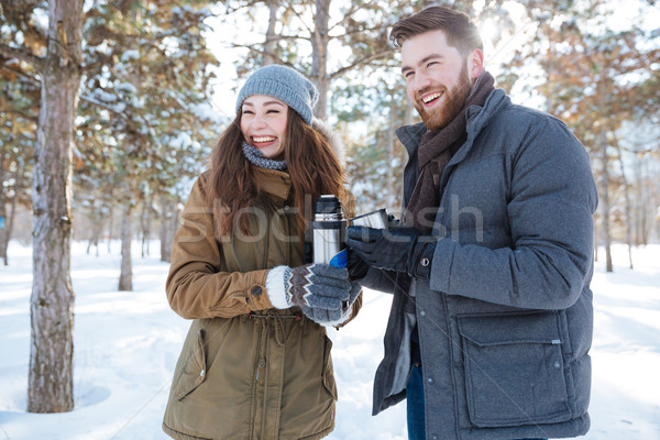 Couple standing with thermos in winter park Stock photo © deandrobot