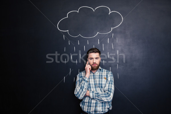 Man talking on mobile phone under rain drawn at blackboard  Stock photo © deandrobot