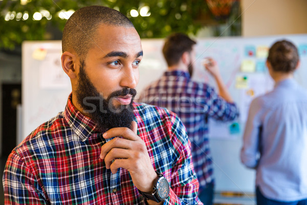 Pensativo africano americano homem em pé escritório Foto stock © deandrobot