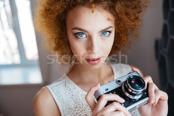 Beautiful redhead curly young woman photographer with vintage camera Stock photo © deandrobot
