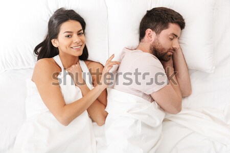 Angry young man lying on the bed with a woman Stock photo © deandrobot