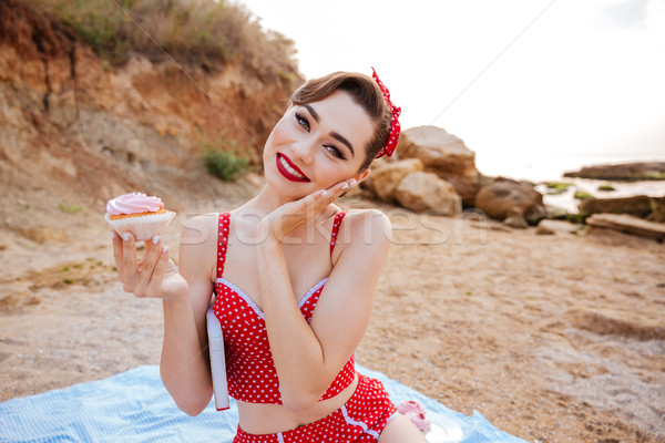 Pin up girl with cream cake sitting at the beach Stock photo © deandrobot