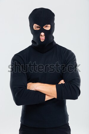 Criminal man in balaclava standing and holding gun Stock photo © deandrobot