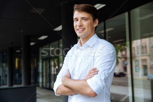 Confident businessman standing with arms crossed Stock photo © deandrobot