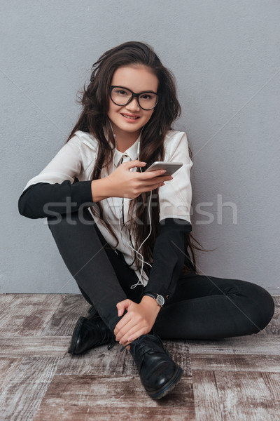 Verticaal afbeelding vrouw luisteren naar muziek vloer glimlachend Stockfoto © deandrobot