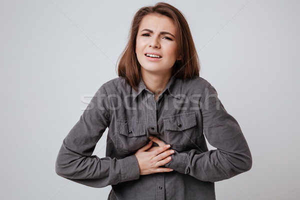 Sick young lady touching belly. Stock photo © deandrobot