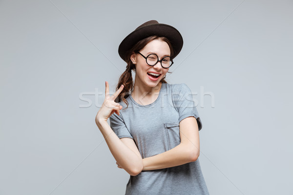 Happy Female nerd showing peace sign Stock photo © deandrobot