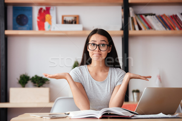 Confused woman indoors reading magazine. Stock photo © deandrobot