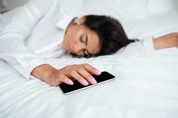 Mujer teléfono móvil mano cama retrato Foto stock © deandrobot