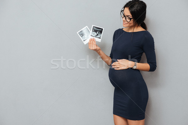 Smiling pregnant business lady holding ultrasound scans Stock photo © deandrobot