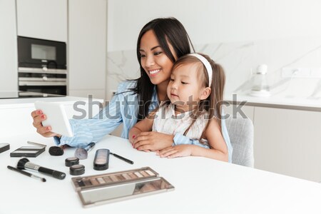 Happy young woman with little daughter make selfie Stock photo © deandrobot