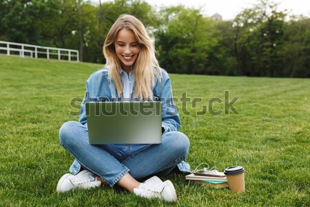 Souriant brunette écolière lunettes séance herbe [[stock_photo]] © deandrobot