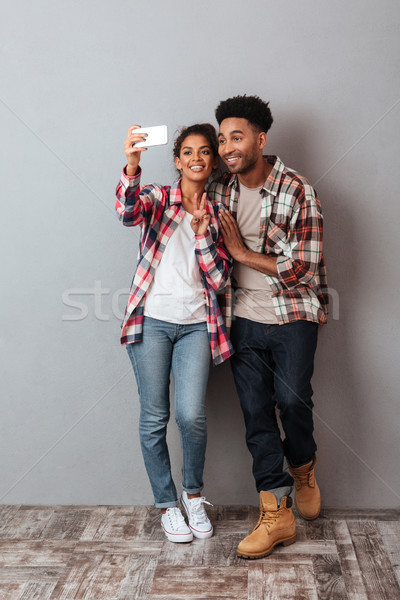 Full length portrait of a happy young african couple Stock photo © deandrobot