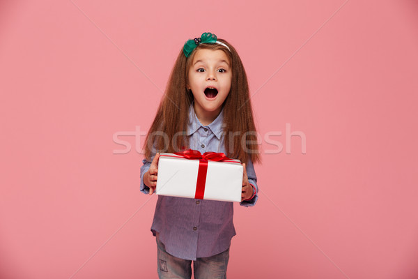 Joyous female kid shouting holding gift-wrapped box being excite Stock photo © deandrobot