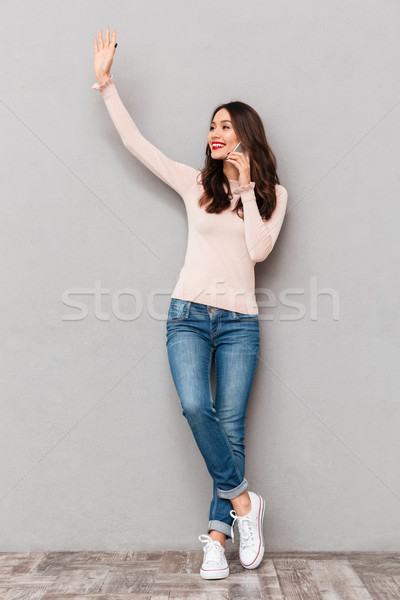 Full-length portrait of feminine smiling lady talking on cell ph Stock photo © deandrobot