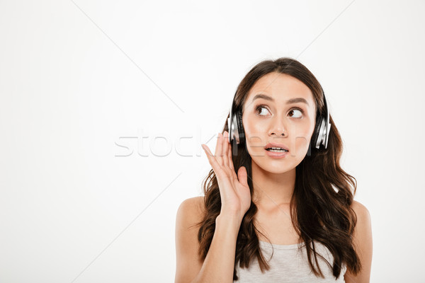 Mystery brunette woman in headphones listening music and looking away Stock photo © deandrobot