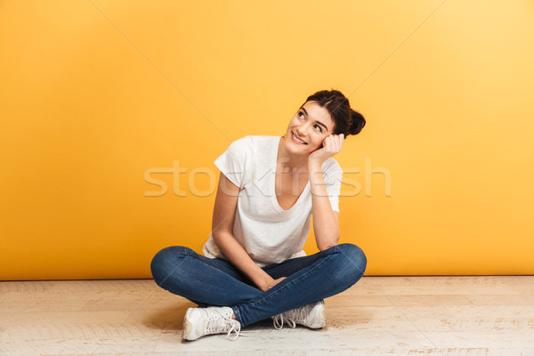 Portrait souriant jeune femme séance jambes croisées étage Photo stock © deandrobot