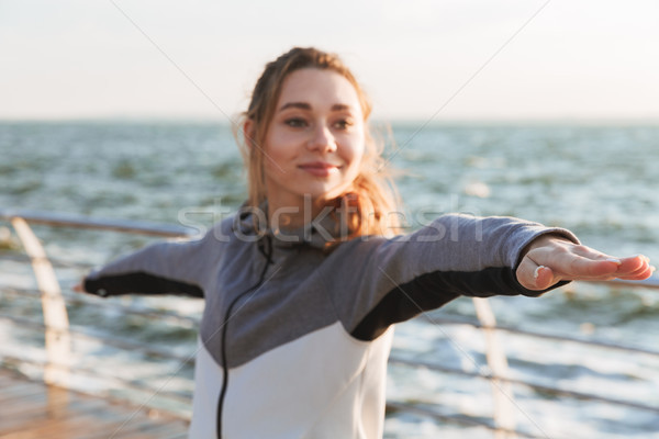 Smiling young girl standing in yoga pose Stock photo © deandrobot