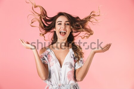 Portrait of a cheerful young woman with long hair jumping Stock photo © deandrobot