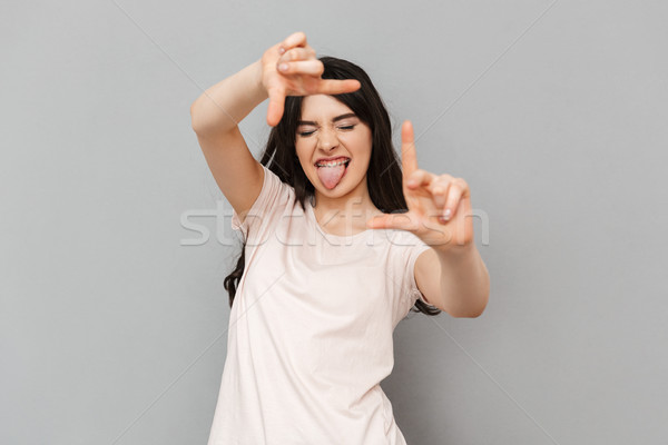 Young lady take a shot of you gesturing with hands Stock photo © deandrobot