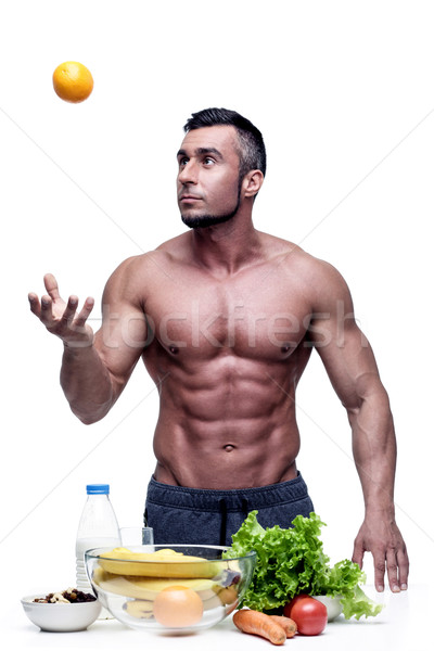 Muscular man juggling orange isolated on white background Stock photo © deandrobot