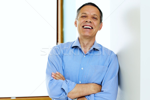 Laughing Senior Man With Hands Folded at home Stock photo © deandrobot