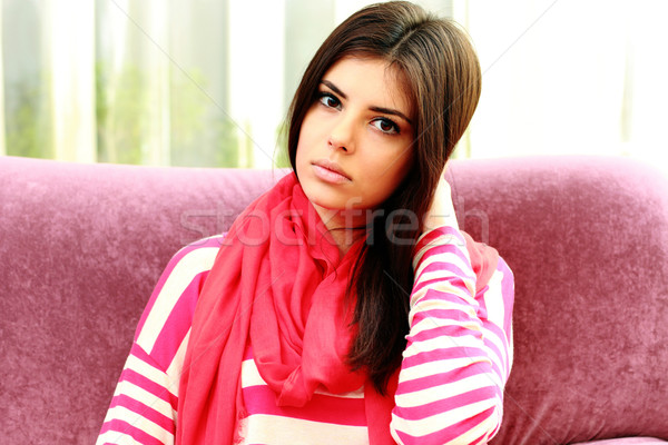 Young thoughtful woman touching her hair at home Stock photo © deandrobot