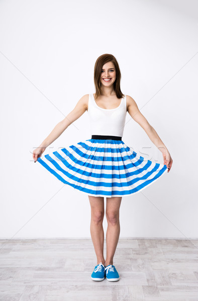Happy young woman holding her dress like a butterfly wing Stock photo © deandrobot