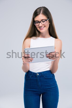 Smiling female teenager in glasses holding tablet compute Stock photo © deandrobot