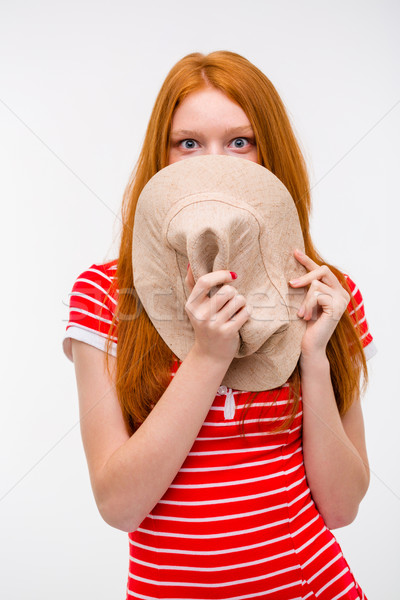 Embarrassed shy woman hiding her face behind hat  Stock photo © deandrobot