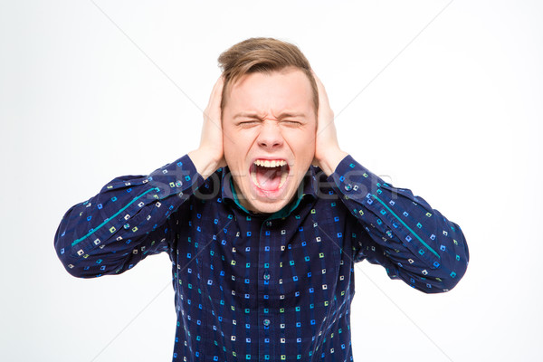 Hysterical mad young man closed ears with hands and screaming  Stock photo © deandrobot