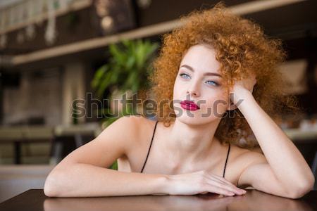 Tempting attractive woman in corset and stockings sitting on sofa  Stock photo © deandrobot