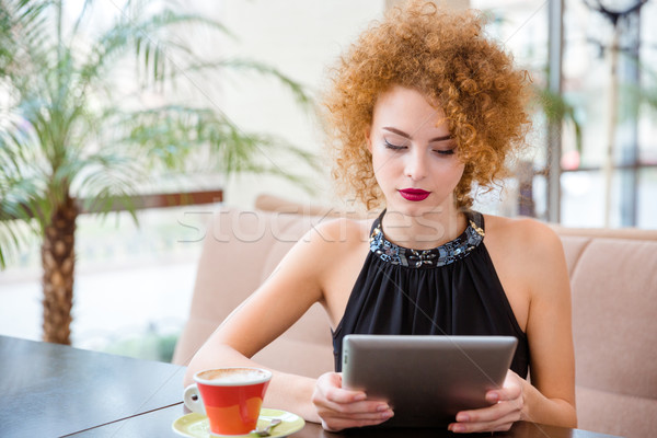 Woman using tablet computer in restaurant Stock photo © deandrobot