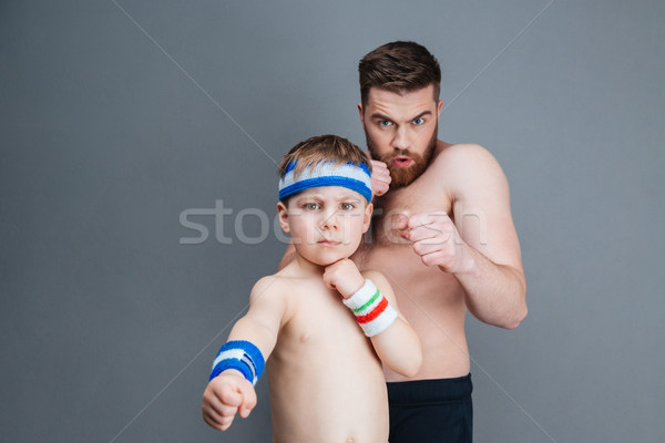 Serious bearded father and his little son punching at camera Stock photo © deandrobot