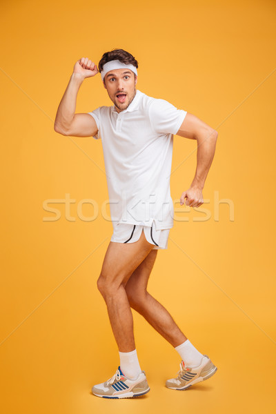 Smiling playful young man athlete standing and posing Stock photo © deandrobot