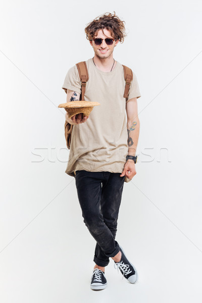 Happy attractive young man holding hat and asking for money Stock photo © deandrobot