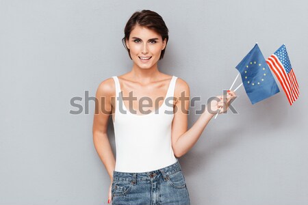 Patriotic smiling woman holding european and usa flags Stock photo © deandrobot
