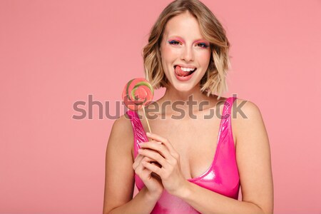 Derűs csinos pinup lány eszik édes Stock fotó © deandrobot