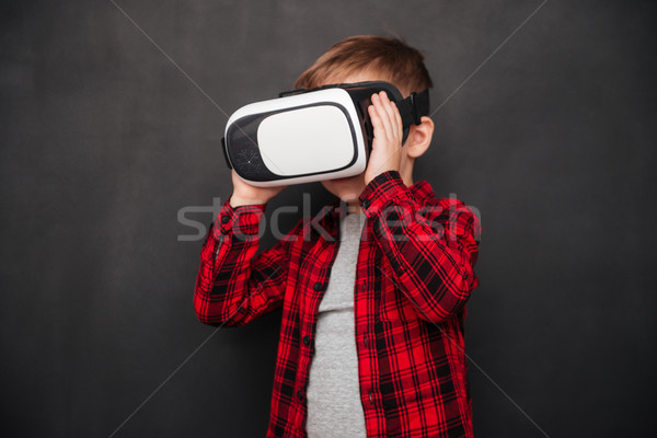 Child wearing and holding virtual reality device over blackboard Stock photo © deandrobot