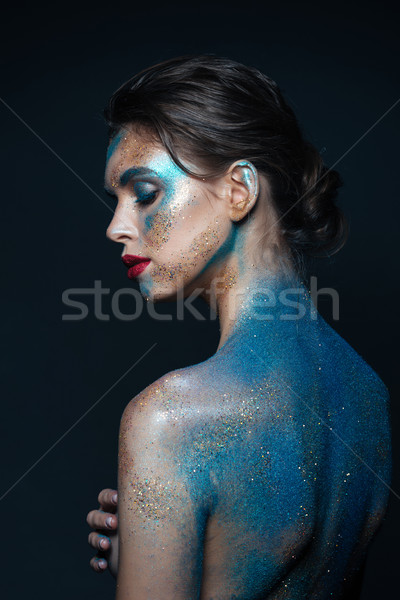 Attractive young woman with blue sparkling makeup on her body Stock photo © deandrobot