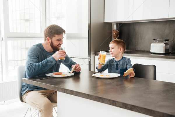 Young father eating at kitchen with his little son Stock photo © deandrobot