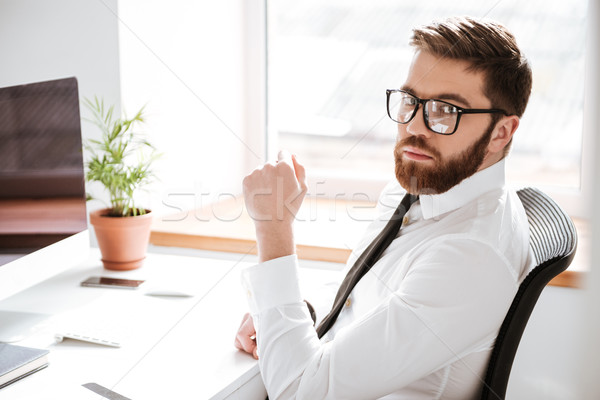 Handsome young businessman looking at camera. Stock photo © deandrobot