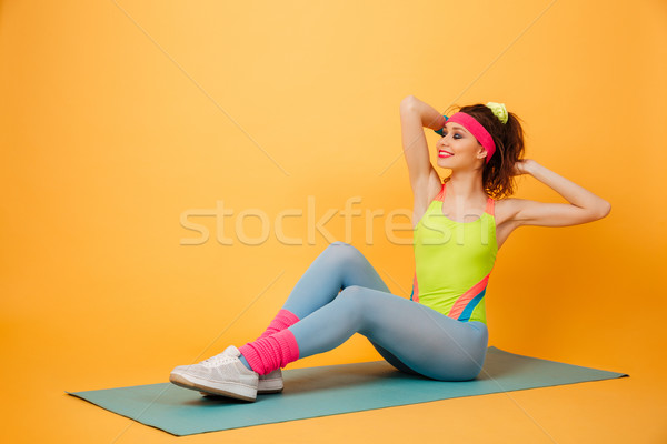 Cheerful young woman athlete training and working out on mat Stock photo © deandrobot
