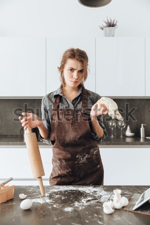Happy lady standing in kitchen and cooking Stock photo © deandrobot