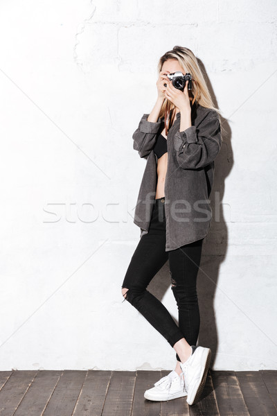Full length portrait of Hipster girl using retro camera Stock photo © deandrobot