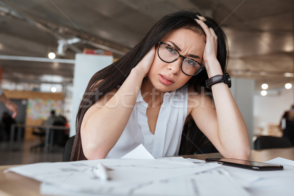 Weary Asian business woman by the table Stock photo © deandrobot
