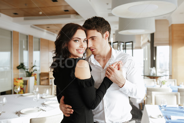 Stock photo: Loving happy couple dancing in restaurant indoors.