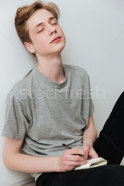 Vertical image of man sitting on  floor with closed eyes Stock photo © deandrobot